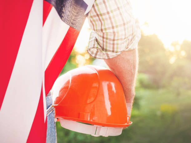 istock Attractive man in work clothes, holding American Flag 1405610891
