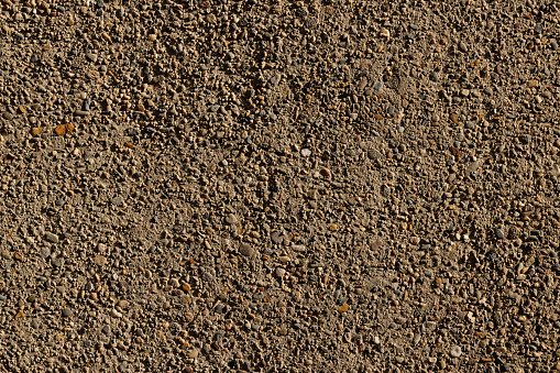 Section of an old concrete wall with small pebbles mixed in.