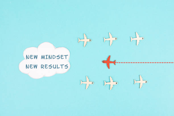 Red airplane is flying to the cloud with the words new mindset new results, changing lifestyle, coaching and improvement concept, positive thinking stock photo
