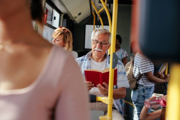 istock Senior man reading book in bus 1405612167