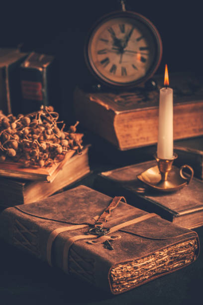 istock Antique leather-bound journal, book or diary with old books and candle 1405612527
