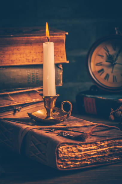 istock Antique leather-bound journal, book or diary with old books and candle 1405612561