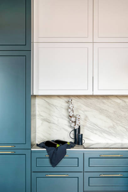 istock Luxury modern and vintage turquoise and white kitchen. Marble wall with white cabinets. Black vase with white dried flowers. Template. 1405613829