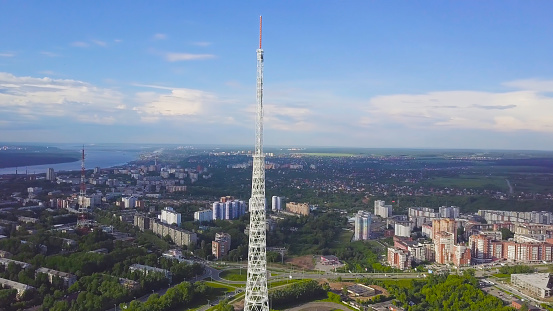 View of communication towers with blue sky, mountain and cityscape background. Video. Top view of the radio tower in the city.