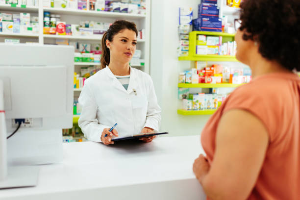 istock Pharmacist giving information to customer at check out 1405619404