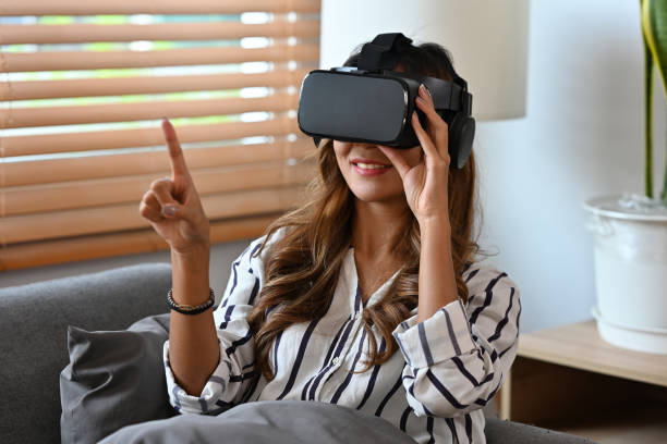istock Young woman wearing virtual reality goggles headset and interacting with virtual reality, entertainment and innovative technology concept 1405623954