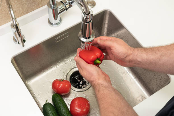 istock man washing vegetables in the kitchen over the sink 1405624802