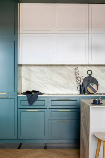 istock Luxury modern and vintage turquoise and white kitchen. Marble wall with white cabinets. Black vase with white dried flowers. Template. 1405627084