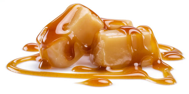 istock Caramel candies covered with melted sugar caramel isolated on white background. 1405627435