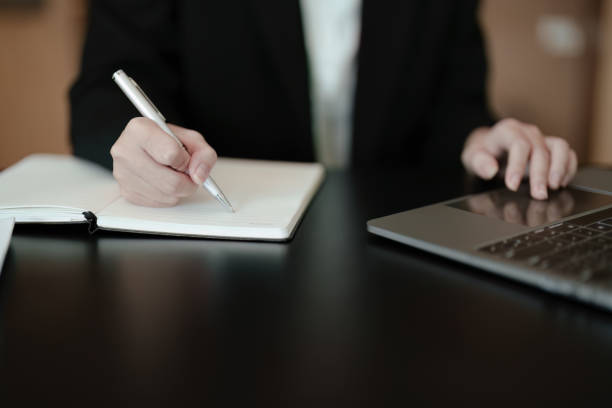 istock usiness woman writing marketing plan in notebook ready to use computer in office 1405627479