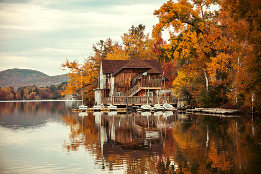 Old boathouse on the side of a lake during the fall