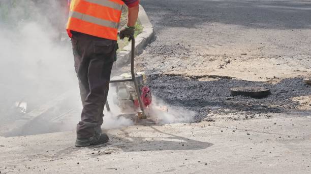 istock Roadworks Construction Worker Using Ground Plate Compactor Flattening Fresh Hot Asphalt 1405629364