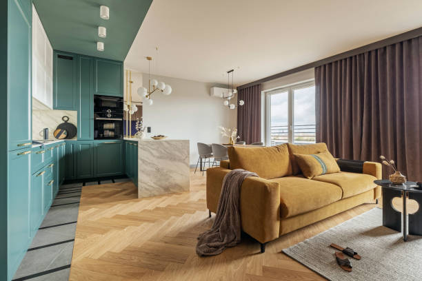 istock Creative and modern vintage open space interior design with yellow sofa and turquoise kitchen with island. Grey carpet on the herringbone parquet with coffee table,  curtain in windows. Template. 
