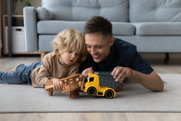 istock Smiling small kid boy playing toys with affectionate daddy. 1405631752