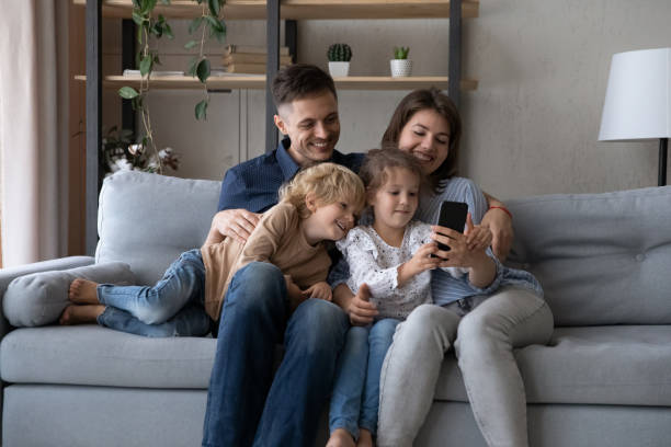 istock Happy relaxed family using cellphone apps at home. 1405632299