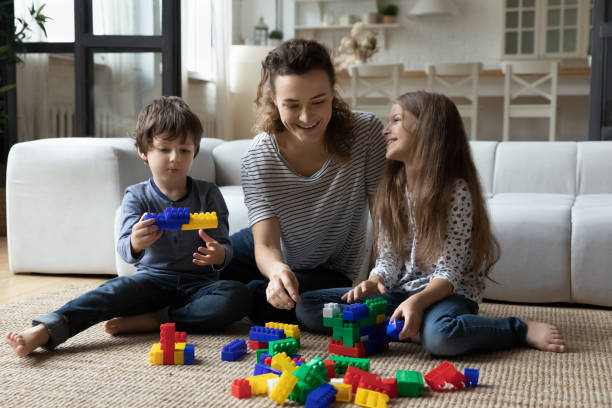 istock Happy mother with son and daughter playing on warm floor 1405636329