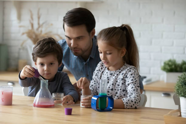 istock Caring father with little kids playing with toy laboratory 1405636354