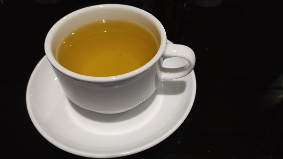 Tea with lemon in a white glass.