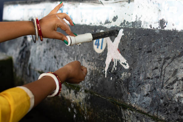 wasserknappheit, hand einer indischen frau bekommt sauberes wasser in die hand von tab am öffentlichen ort. - sustainable resources water conservation water faucet stock-fotos und bilder