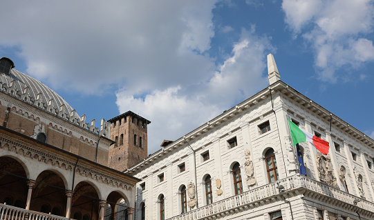 Padua, PD, Italy - May 15, 2022: Building called PALAZZO DELLA RAGIONE and MORONI PALACE and a bell tower with big italian Flag