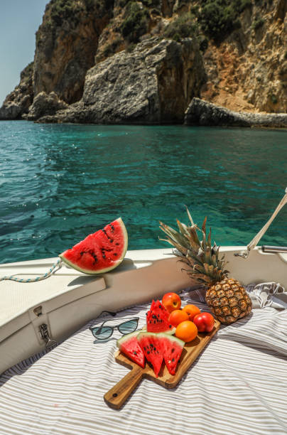 그리스 석호에서 보트에서 수박과 과일 피크닉 - corfu greece sea beach 뉴스 사진 이미지