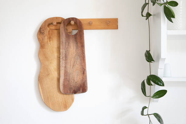 istock Wooden cutting board collection hang on the wall. Cozy rustic style modern kitchen interior detail, green plant and white shelf. Decoration in traditional kitchen. 1405639017