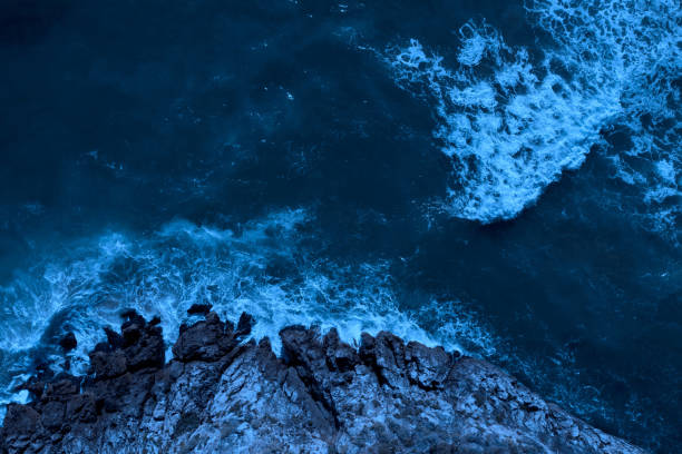 istock Moonlight ocean: sea waves splashing on cliffs 1405639259
