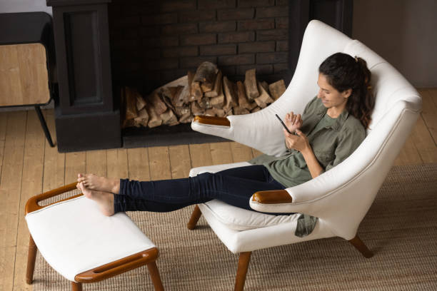 istock Relaxed young barefoot woman using cellphone, resting at home. 1405640903
