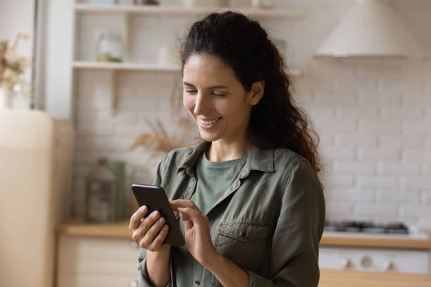 istock Happy millennial latina woman using cellphone at home. 1405640936