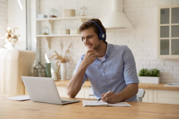 istock Smiling millennial man studying on online courses. 1405640939