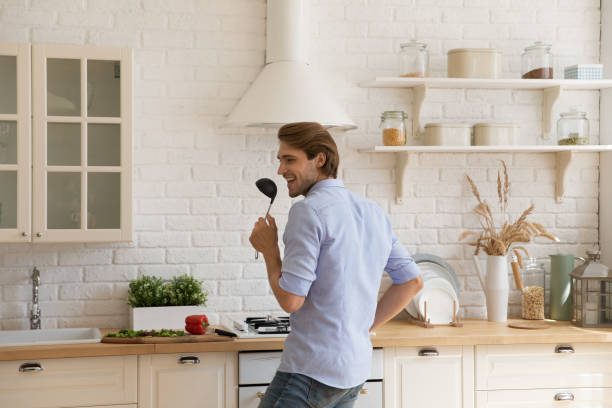 istock Happy young man having fun in modern kitchen. 1405640950
