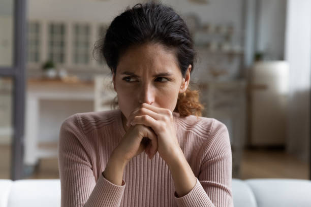 istock Thoughtful unhappy latin female sit on couch with sad look 1405643437