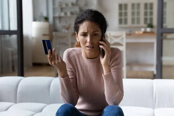 Photo of Worried young hispanic woman call bank unable pay by card