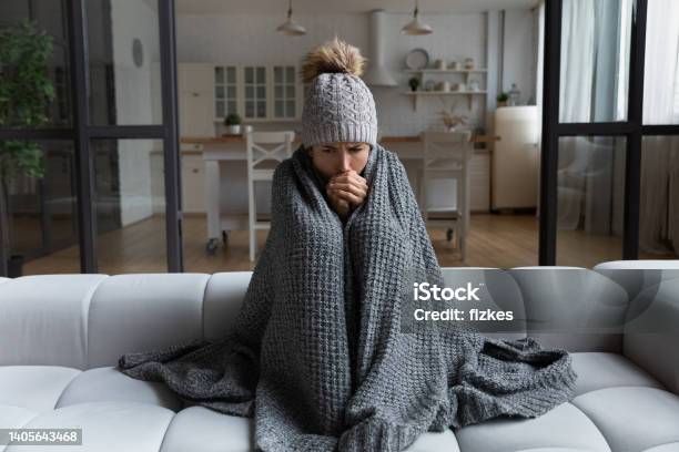 Latina Female Shiver At Freezing Flat In Warm Cap Blanket Stock Photo - Download Image Now