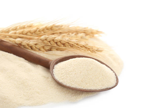 istock Spoon with semolina and spikelets on white background 1405647164