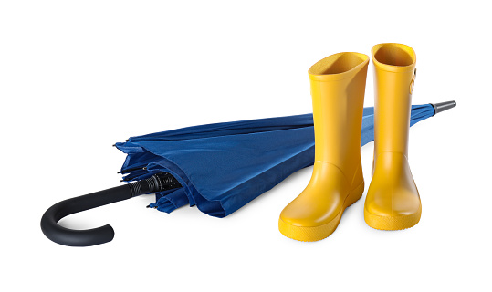 Yellow rubber boots and blue umbrella on white background