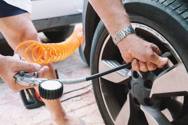 Close up of a mechanic inflating a car tire Man filling Air into the Tire. Car Driver Checking Air Pressure and Maintenance his Car by himself before Traveling. Car insurance concept air pump stock pictures, royalty-free photos & images