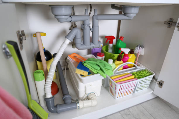 istock Open under sink cabinet with different cleaning supplies in kitchen 1405648525