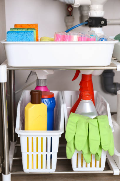 istock Open under sink cabinet with different cleaning supplies in kitchen 1405648530
