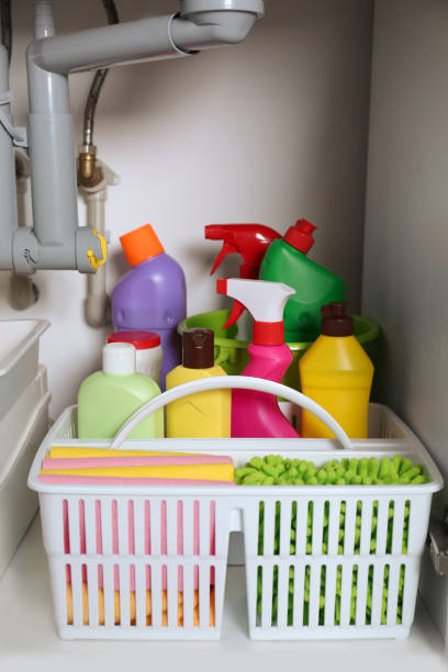 istock Open under sink cabinet with different cleaning supplies in kitchen 1405648557