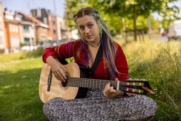 istock LGBTQ+ young woman playing guitar outdoors, with alternative hairstyle as self-expression giving confidence to be accepted 1405649618