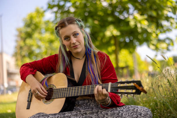 istock LGBTQ+ young woman playing guitar outdoors, with alternative hairstyle as self-expression giving confidence to be accepted 1405649645