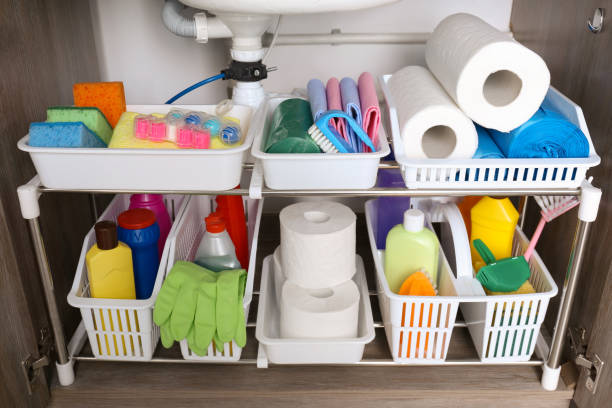 istock Open under sink cabinet with different cleaning supplies in kitchen 1405649913
