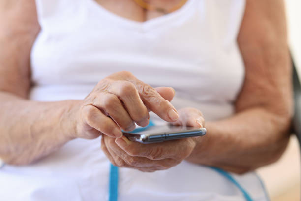 istock Old woman holding modern smartphone in hands 1405654081
