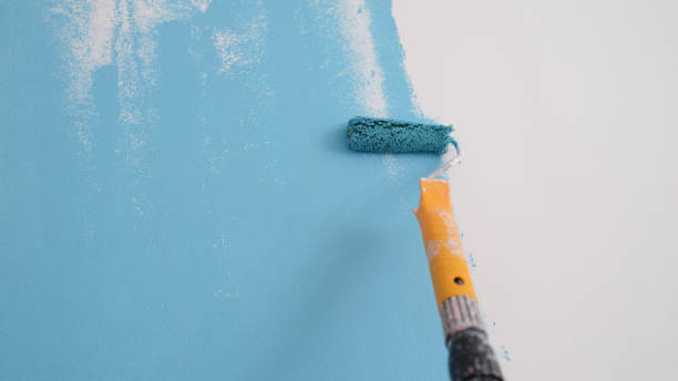 istock Professional decorator painting wall in blue color. 1405654091