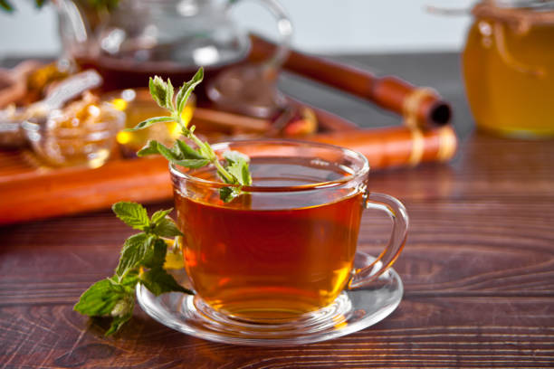 istock Cup of herbal mint tea with dry herbs on the tray. 1405654291
