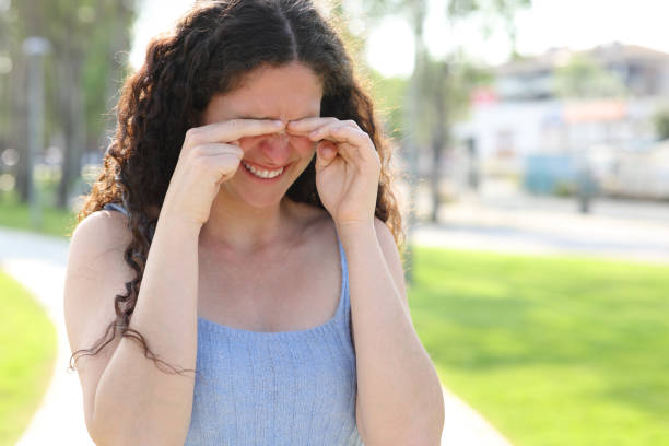 istock Woman scratching itchy eyes while walks in a park 1405654417