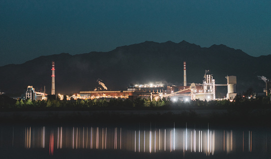 A large aluminum and steel mill illuminated at night in the industrial area
