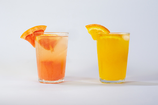 Photo of a glass of orange juice and a glass of grapefruit juice