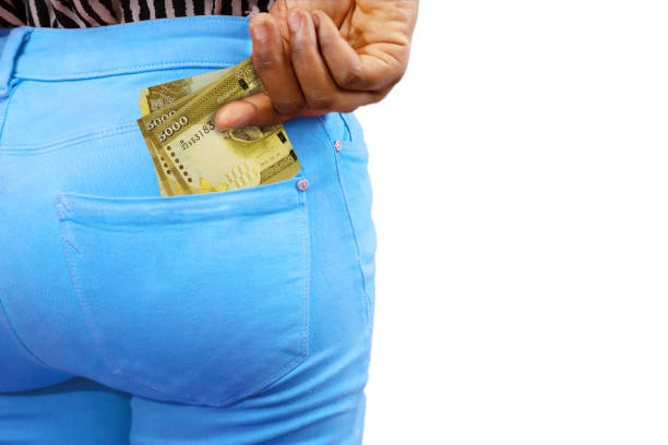 istock Black lady putting few 5000 Sri Lankan rupee notes into her back pocket. Removing money from pocket, hold money 1405656904